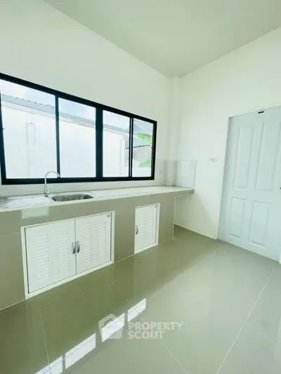 Modern kitchen with sleek design and large window for natural light