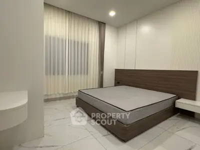 Modern minimalist bedroom with sleek design and ample natural light