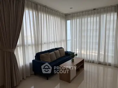 Spacious living room with floor-to-ceiling windows and modern furnishings