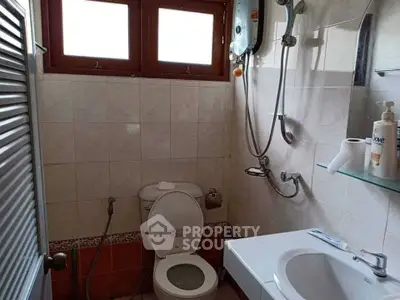 Compact bathroom with shower and toilet in a cozy home setting.