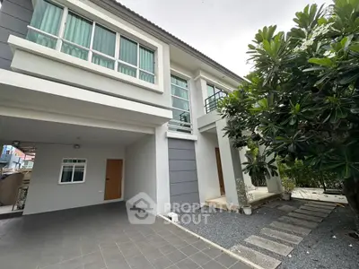 Modern two-story house with spacious driveway and lush garden