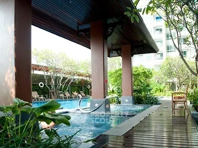 Luxurious outdoor pool area with lush greenery and modern design, perfect for relaxation and leisure.
