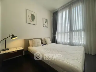 Modern bedroom with large windows and stylish decor in a luxury apartment.
