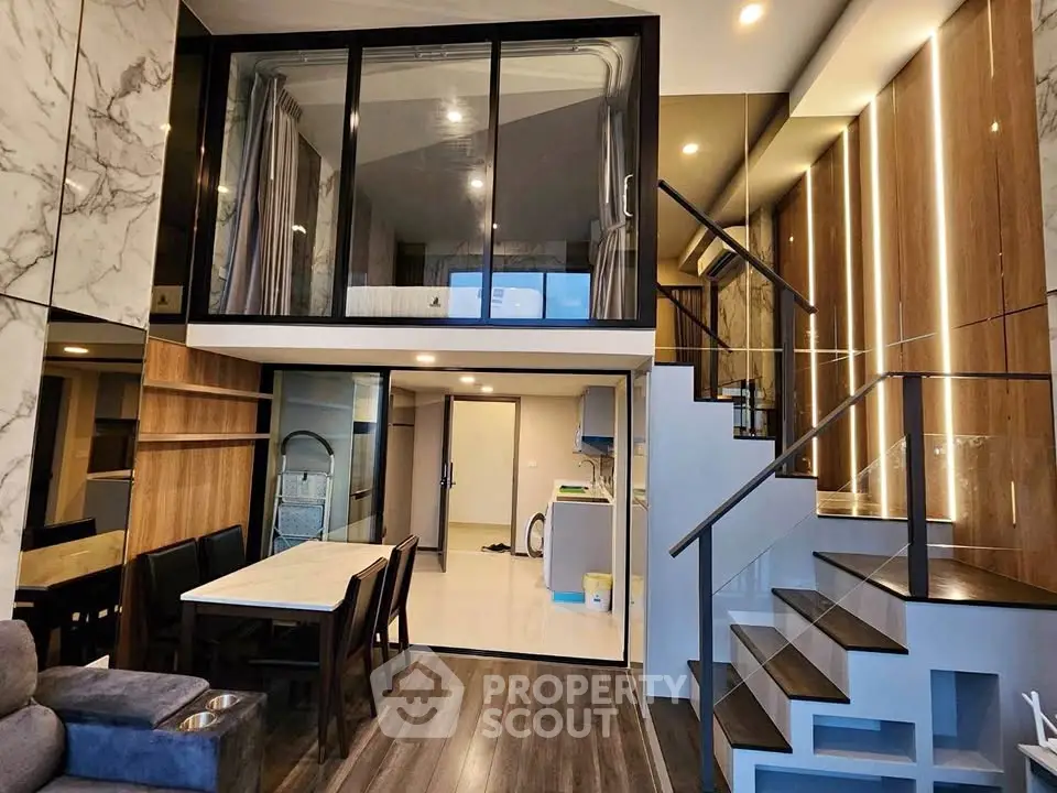 Luxurious modern duplex with elegant staircase and stylish dining area, perfect for contemporary living.