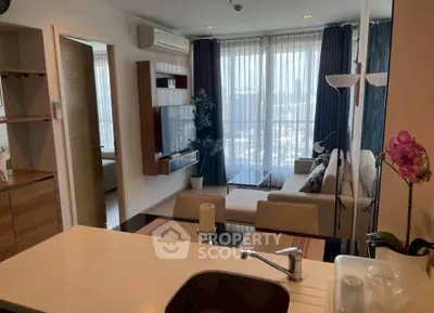 Modern living room with large windows and stylish decor in a high-rise apartment.