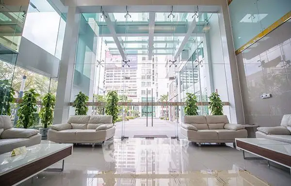 Luxurious modern building entrance with glass walls and elegant seating area.