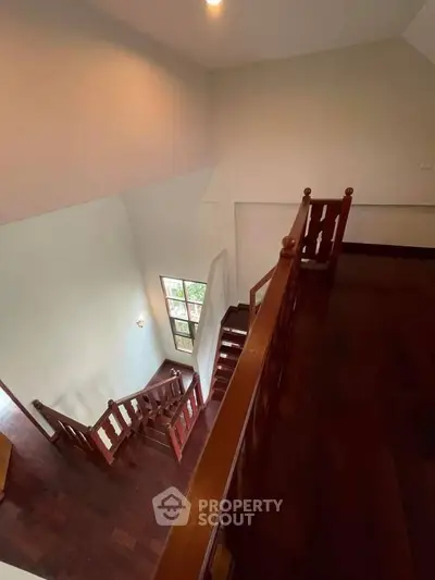 Elegant wooden staircase with polished railing in a spacious home interior