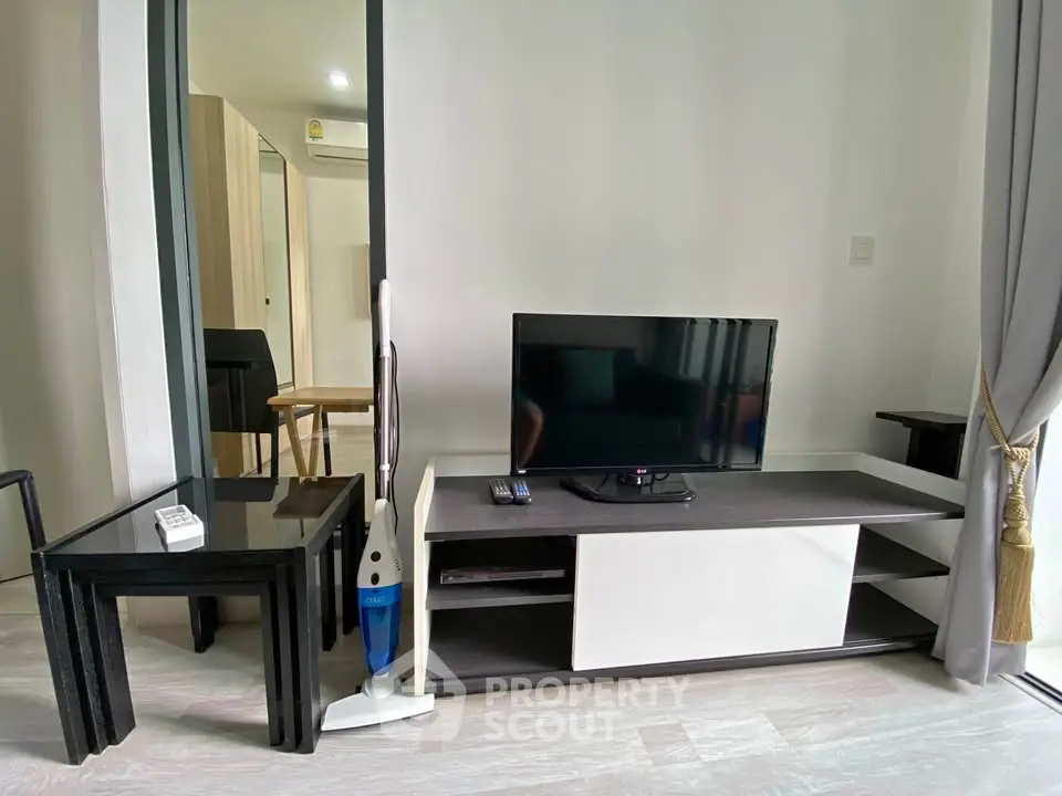Modern living room with sleek furniture and TV setup in a stylish apartment.