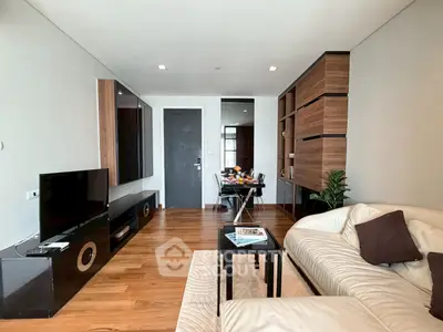 Modern living room with sleek wooden flooring, stylish furniture, and a cozy ambiance perfect for relaxation.