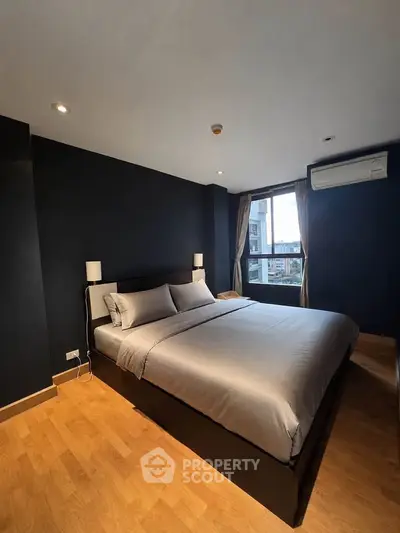 Modern bedroom with stylish decor and city view, featuring a comfortable bed and sleek design.