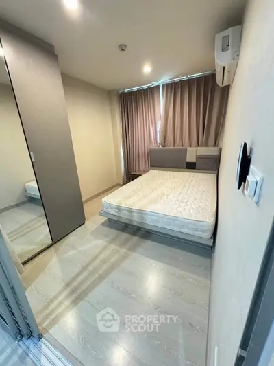 Modern bedroom with minimalist design, featuring a comfortable bed, mirrored wardrobe, and soft lighting.