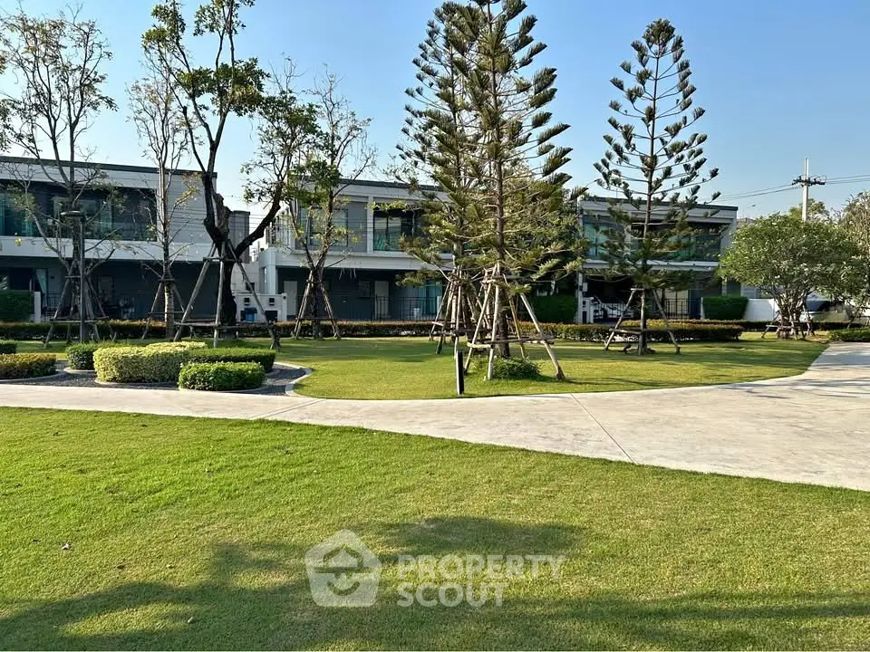 Modern residential complex with lush green landscaping and contemporary architecture.