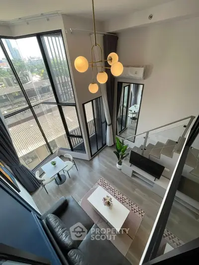 Stunning loft apartment with floor-to-ceiling windows and modern decor, offering a spacious and bright living area.