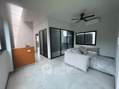 Modern living room with cozy sectional sofa and large windows in a stylish home.