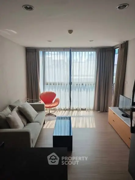 Modern living room with large windows and stylish furniture in a bright apartment.