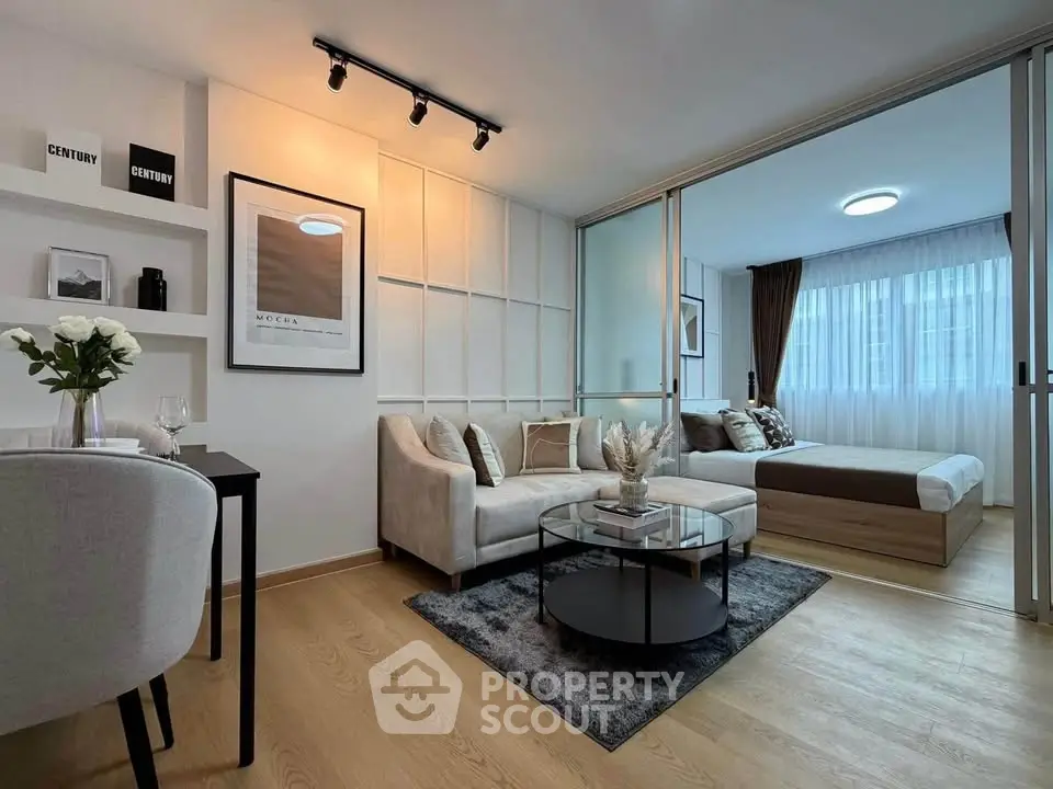 Modern open-plan living room with stylish decor and cozy bedroom in a chic apartment.