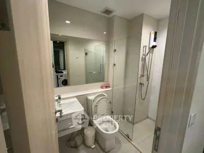 Modern bathroom with glass shower and washing machine view