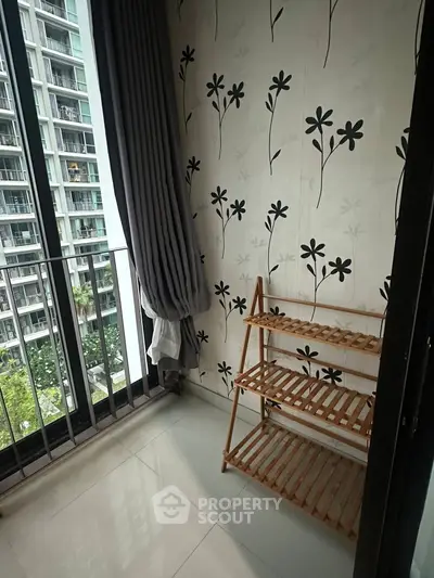 Charming small balcony with floral wallpaper and city view, perfect for relaxation.
