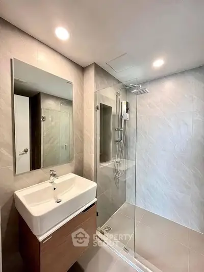 Modern bathroom with sleek shower and stylish vanity in contemporary home.