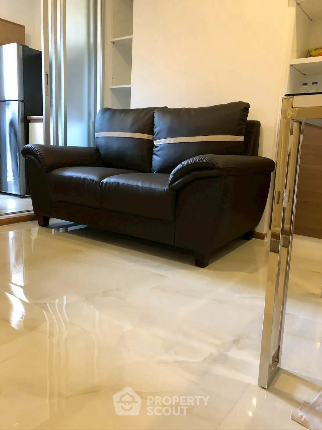 Modern living room with sleek leather sofa and polished tile flooring.