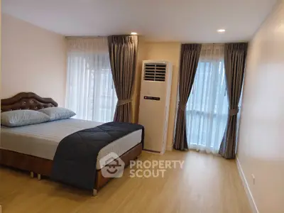 Spacious bedroom with elegant curtains and modern air conditioning unit