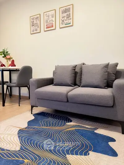 Stylish living room with modern gray sofa and artistic rug, perfect for cozy urban living.