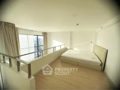 Spacious loft bedroom with large windows and city view, featuring minimalist design and natural light.