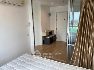 Modern bedroom with mirrored closet and air conditioning in a high-rise apartment.