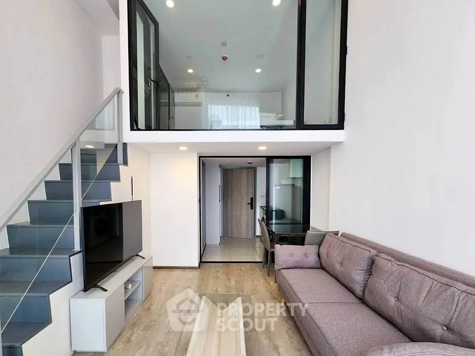 Modern duplex living room with stylish staircase and cozy seating area