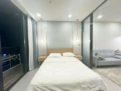 Modern bedroom with balcony access and stylish lighting in luxury apartment