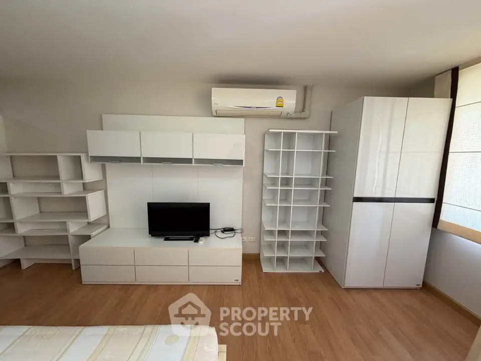 Modern living room with sleek white furniture and wooden flooring