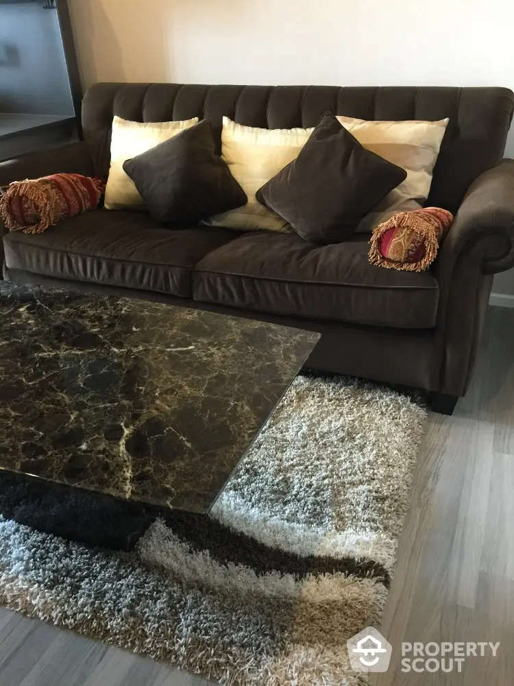 Stylish living room with plush sofa and elegant marble coffee table on chic rug.