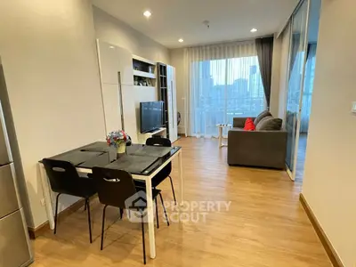 Modern living room with city view, stylish furniture, and wooden flooring.