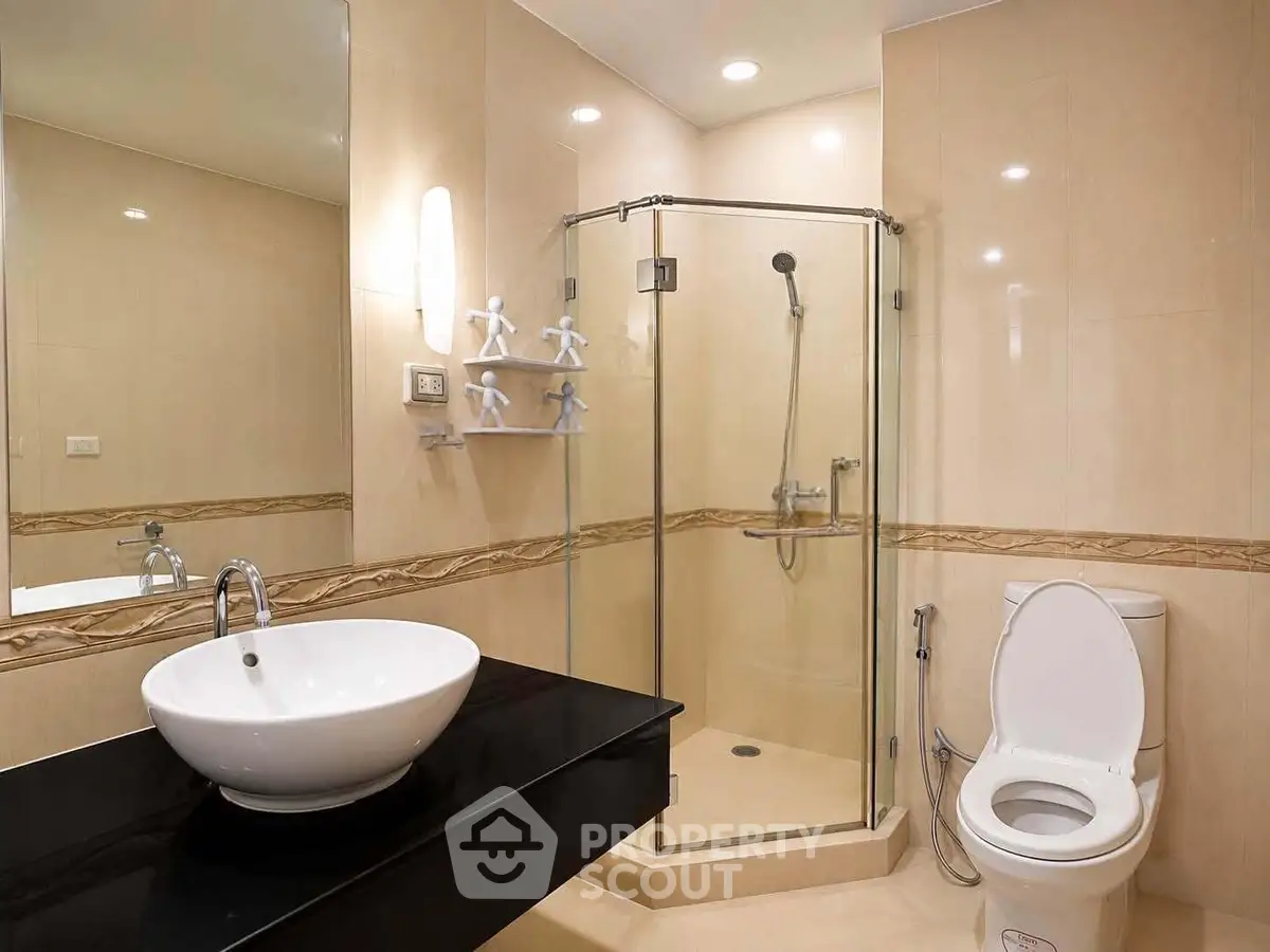 Modern bathroom with glass shower and sleek fixtures in luxury apartment.