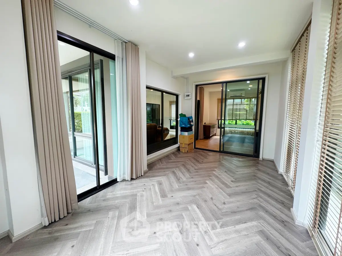 Spacious modern living room with large windows and elegant flooring