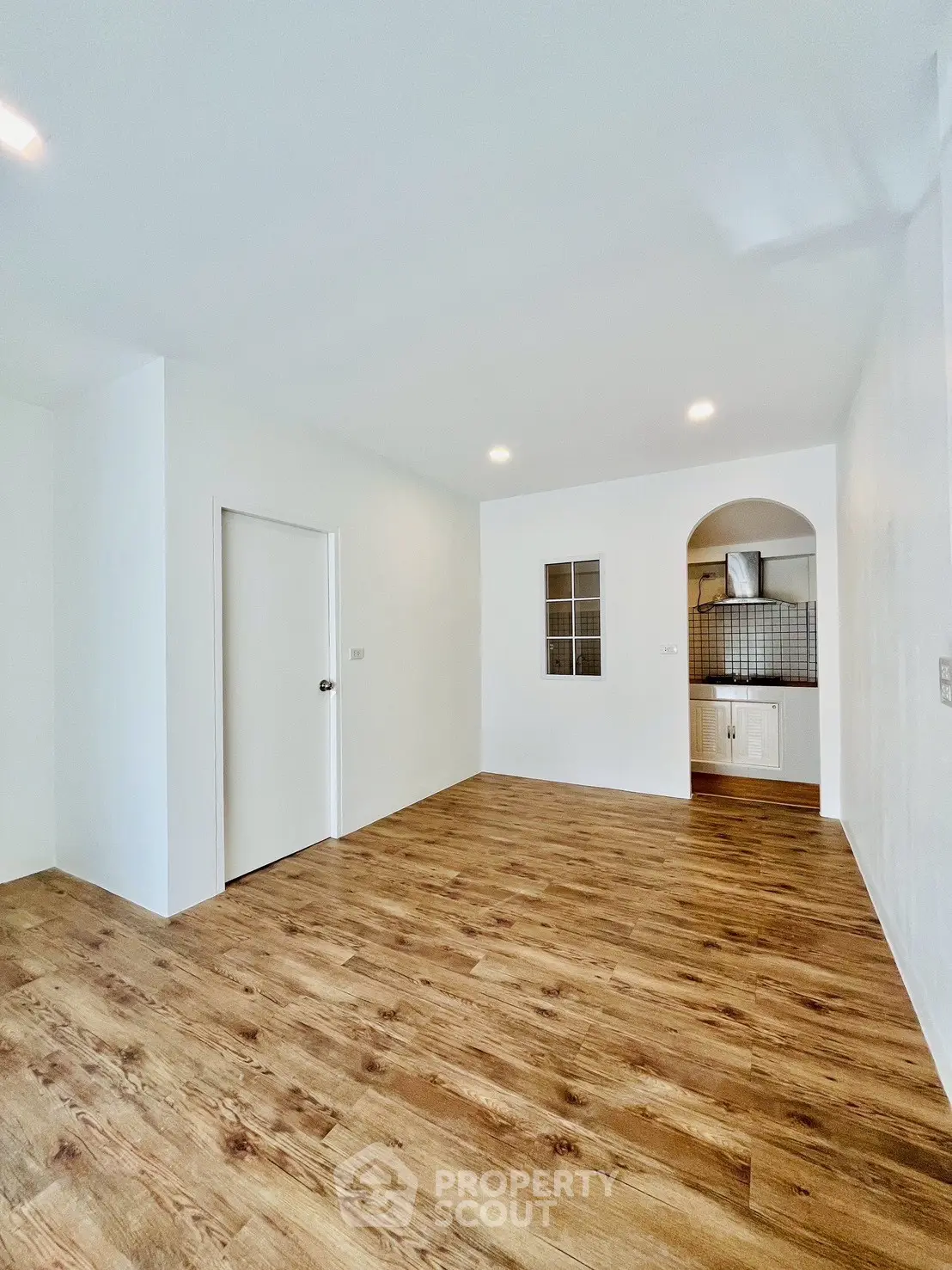 Spacious living room with wooden flooring and modern kitchen nook