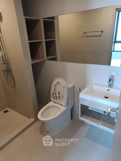 Modern bathroom with sleek fixtures and large mirror in a contemporary apartment.