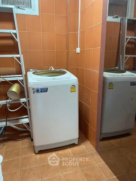 Compact laundry room with washing machine and tiled walls