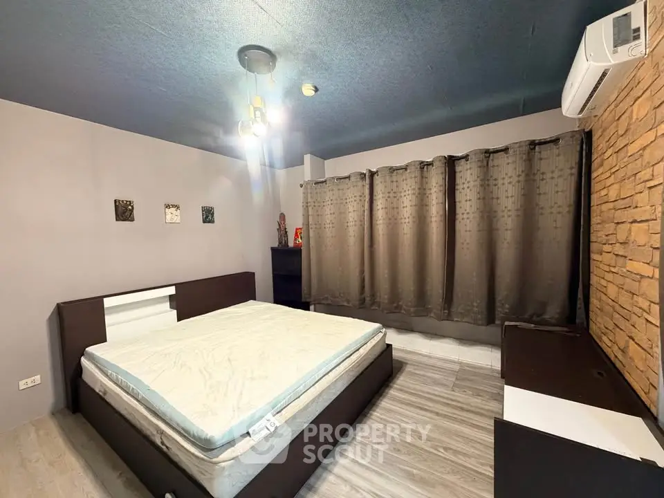 Spacious modern bedroom with stylish decor and air conditioning, perfect for comfort and relaxation.