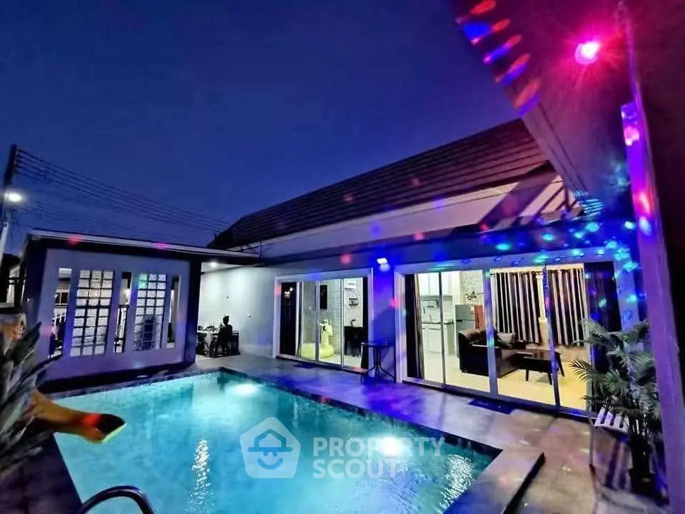 Stunning modern home with illuminated pool and stylish exterior lighting at dusk.