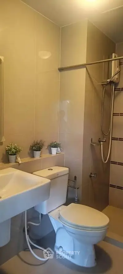 Modern bathroom with sleek fixtures and shower area in a contemporary apartment.
