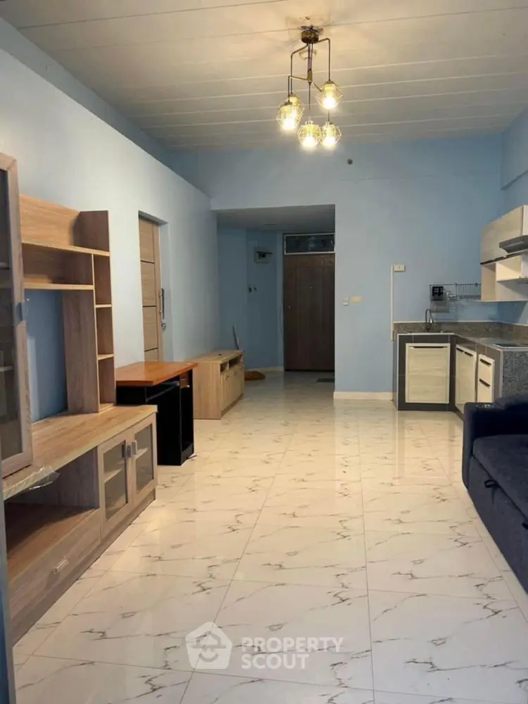 Spacious living room with modern furniture and open kitchen layout.