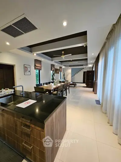 Luxurious open-plan kitchen and dining area with modern design and elegant lighting.