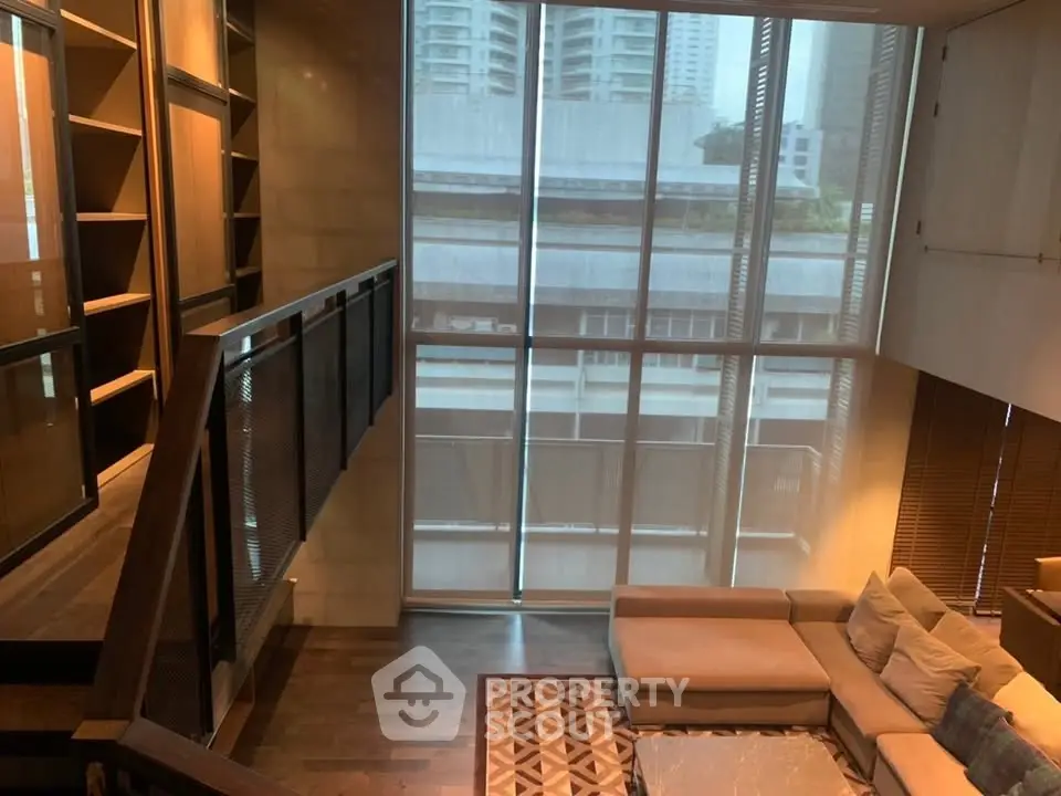 Luxurious modern living room with large windows and elegant staircase in urban apartment.