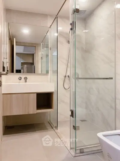 Modern bathroom with glass shower and sleek fixtures in a contemporary apartment.