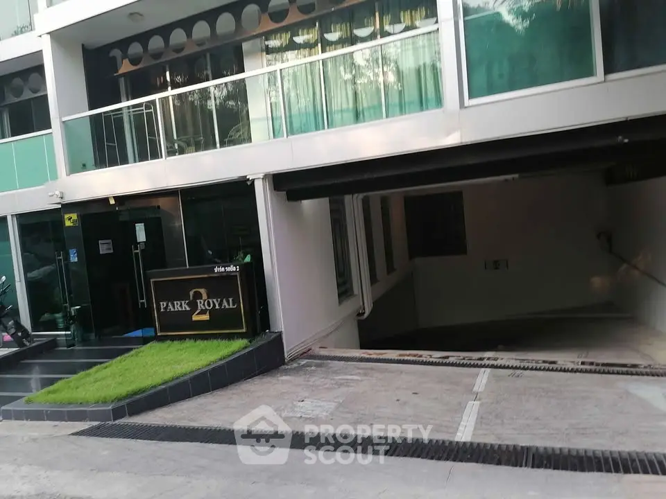 Modern building entrance with parking garage and stylish glass facade