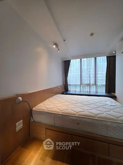 Modern bedroom with large window and wooden flooring