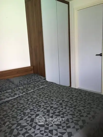 Cozy bedroom with modern geometric bedding and sleek wardrobe design.