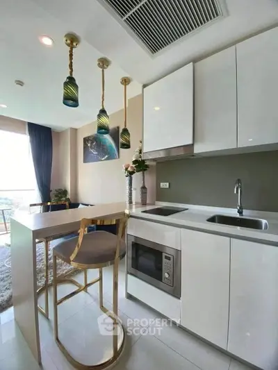 Modern kitchen with sleek white cabinets and stylish pendant lighting