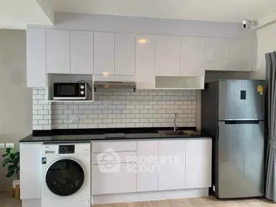 Modern kitchen with sleek white cabinets, stainless steel appliances, and subway tile backsplash.